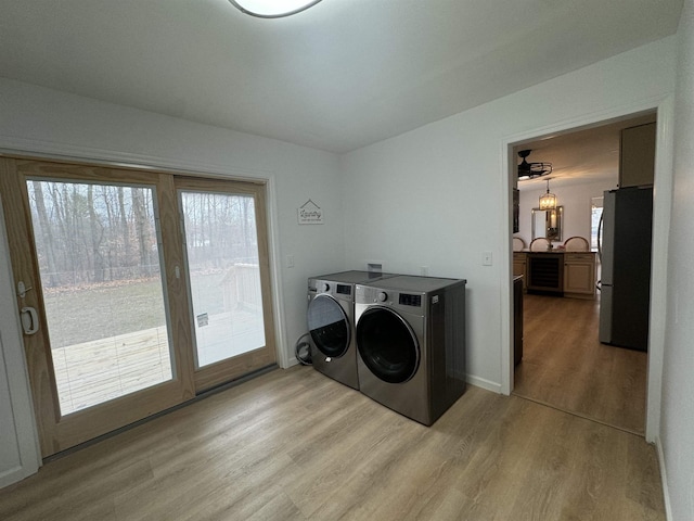 washroom with separate washer and dryer, a wealth of natural light, light hardwood / wood-style flooring, and wine cooler