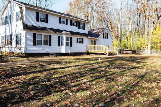 rear view of house with a yard and a deck