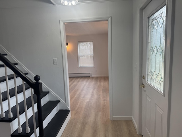 entrance foyer featuring a baseboard heating unit and light hardwood / wood-style floors