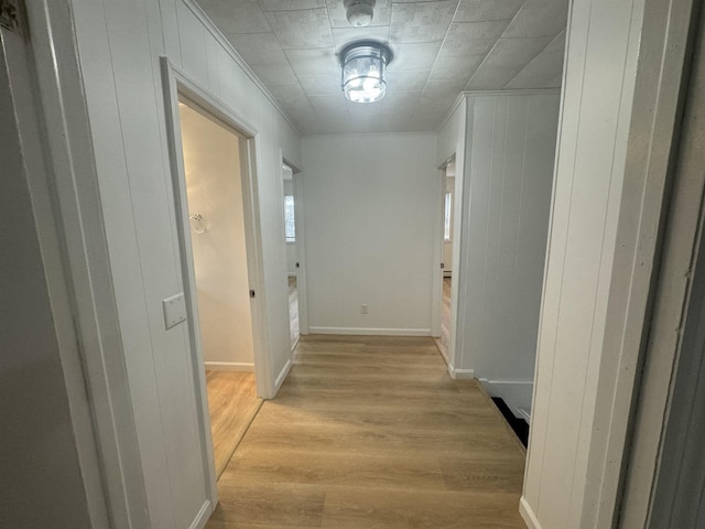 hallway featuring ornamental molding and light wood-type flooring