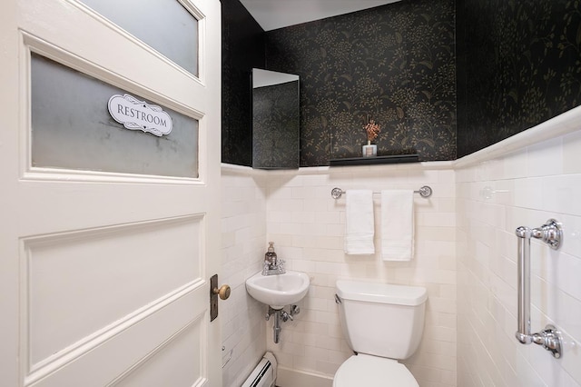 bathroom featuring baseboard heating, toilet, and tile walls