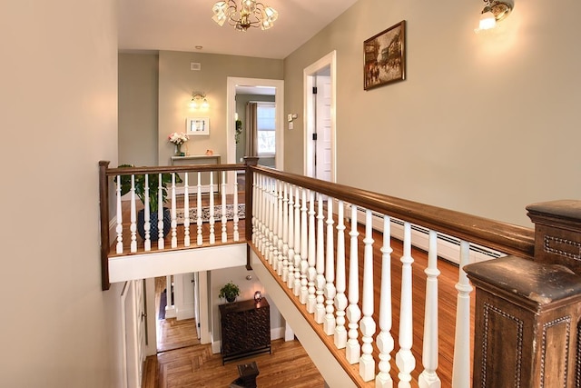 hall with hardwood / wood-style floors and a notable chandelier