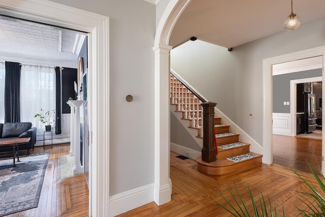 stairway featuring baseboard heating and parquet floors