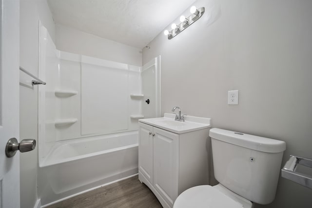 full bathroom with hardwood / wood-style flooring, vanity, shower / bath combination, and toilet