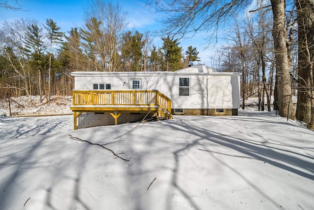 snow covered rear of property featuring a deck