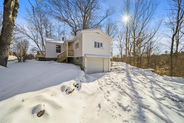 view of snowy exterior with a garage