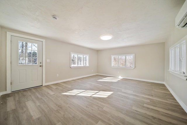 entrance foyer featuring light hardwood / wood-style flooring and an AC wall unit