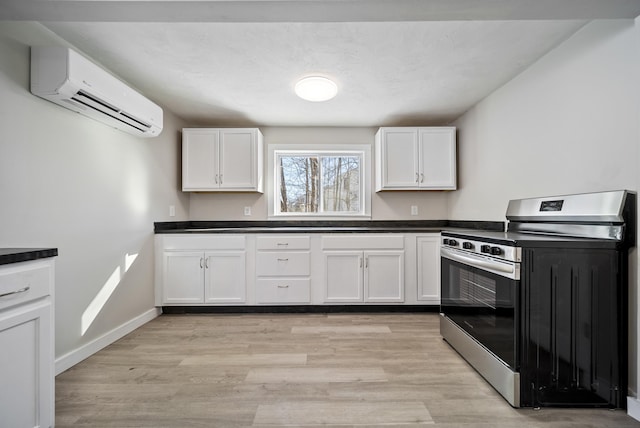 kitchen with white cabinetry, a wall mounted AC, electric range, and light wood-type flooring