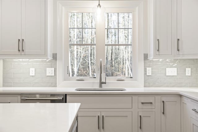 kitchen with white cabinetry, dishwasher, sink, and pendant lighting