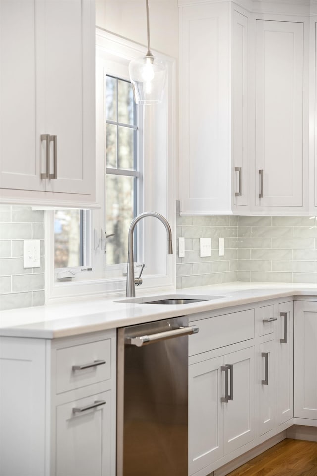 kitchen featuring dishwasher, white cabinets, and decorative light fixtures