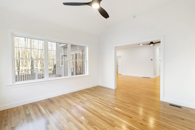 empty room with ceiling fan, lofted ceiling, and light wood-type flooring