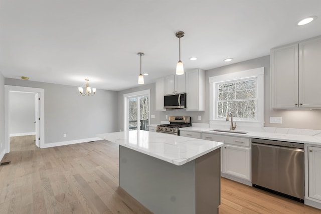 kitchen with a kitchen island, white cabinetry, appliances with stainless steel finishes, and sink