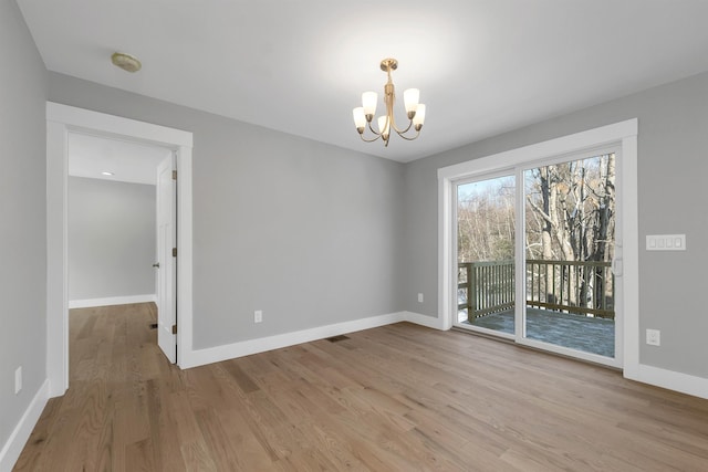 unfurnished dining area featuring an inviting chandelier and light hardwood / wood-style flooring