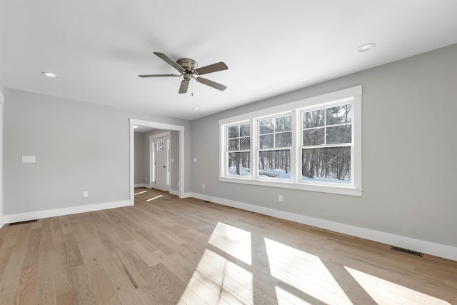 unfurnished room featuring ceiling fan, a healthy amount of sunlight, and light hardwood / wood-style floors