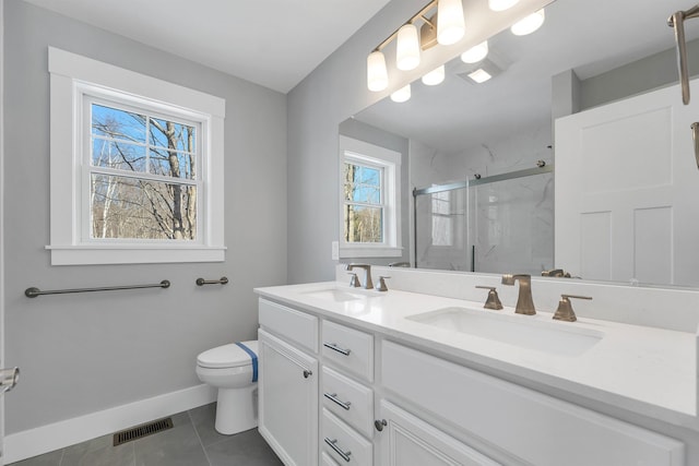 bathroom featuring vanity, toilet, tile patterned floors, and a shower with shower door