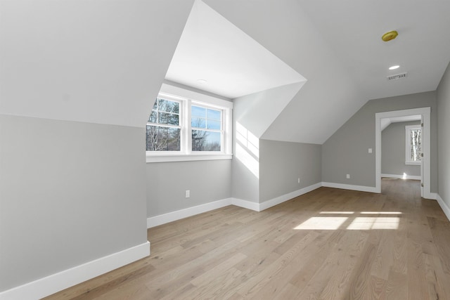 additional living space with lofted ceiling and light wood-type flooring