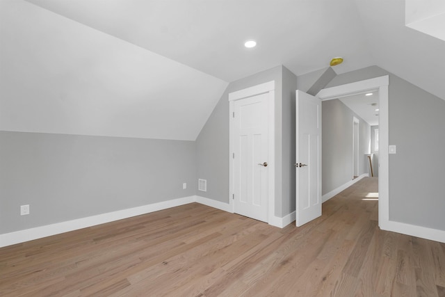 additional living space with lofted ceiling and light wood-type flooring