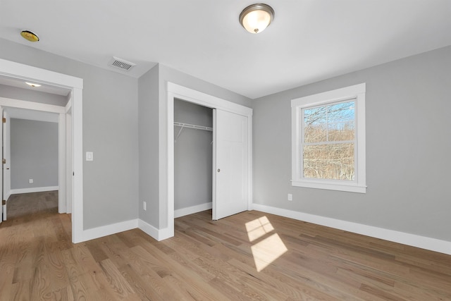 unfurnished bedroom featuring light hardwood / wood-style flooring and a closet