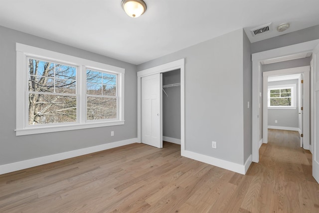 unfurnished bedroom featuring a closet and light wood-type flooring