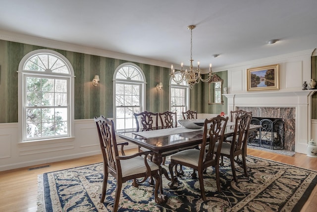 dining area featuring plenty of natural light, a fireplace, and light wood-type flooring