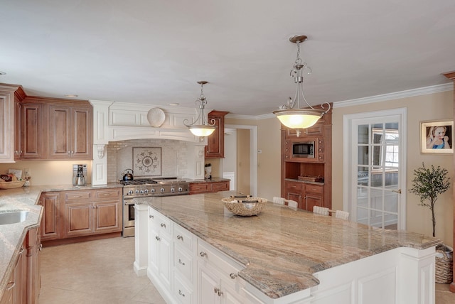 kitchen with pendant lighting, light stone counters, stainless steel appliances, and a center island