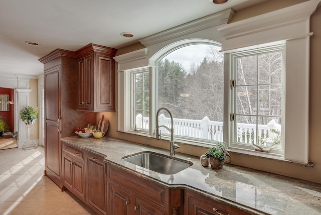 kitchen featuring light stone counters, sink, and light tile patterned floors