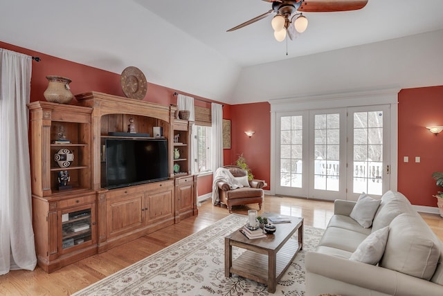 living room featuring vaulted ceiling, ceiling fan, and light hardwood / wood-style floors