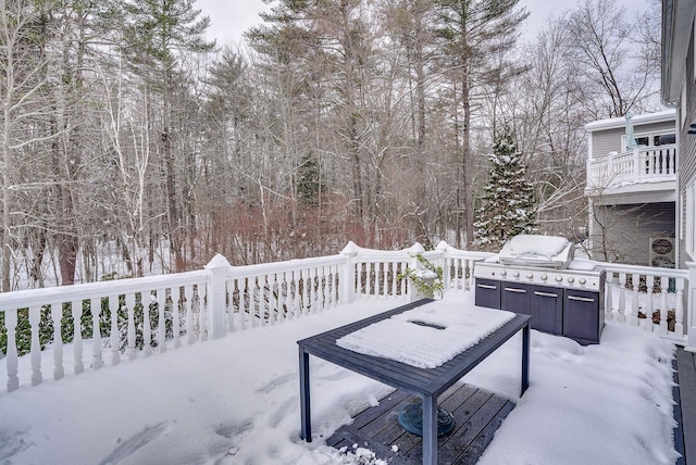 snow covered patio with a wooden deck