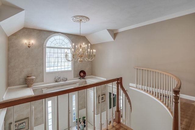 hallway featuring lofted ceiling, a notable chandelier, ornamental molding, and hardwood / wood-style floors