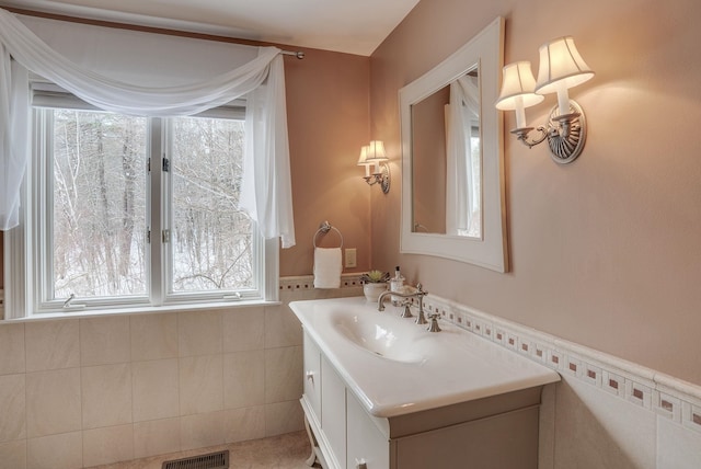 bathroom featuring vanity and tile walls