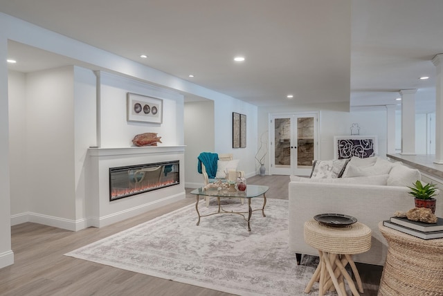 living room featuring light hardwood / wood-style floors and ornate columns