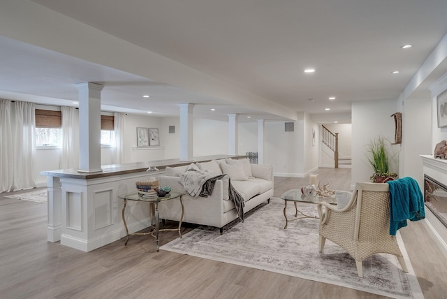 living room featuring decorative columns and light hardwood / wood-style flooring