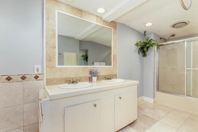 full bathroom with lofted ceiling, double vanity, a sink, and tile walls