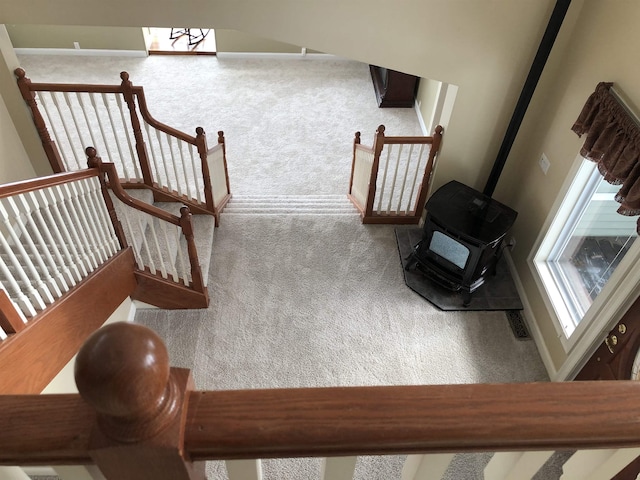 stairs featuring carpet and a wood stove