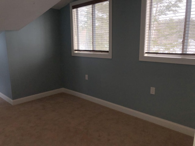 interior space featuring baseboards, vaulted ceiling, and carpet flooring