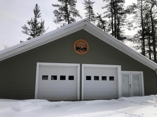 snow covered garage featuring a detached garage