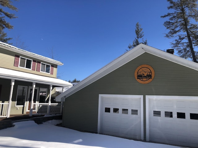 view of home's exterior with a garage, a porch, and an outdoor structure