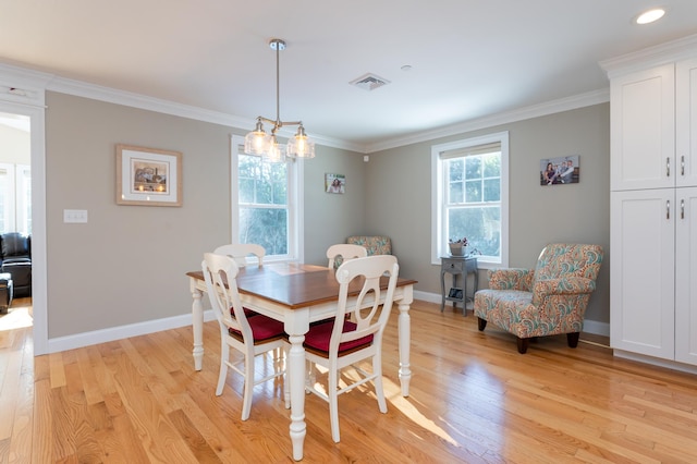 dining space featuring ornamental molding and light hardwood / wood-style floors