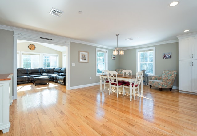 dining area with crown molding, plenty of natural light, and light wood-type flooring