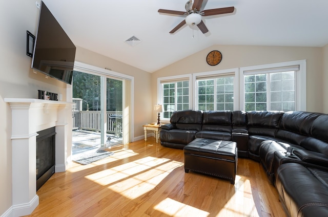 living room with lofted ceiling, ceiling fan, and light hardwood / wood-style flooring