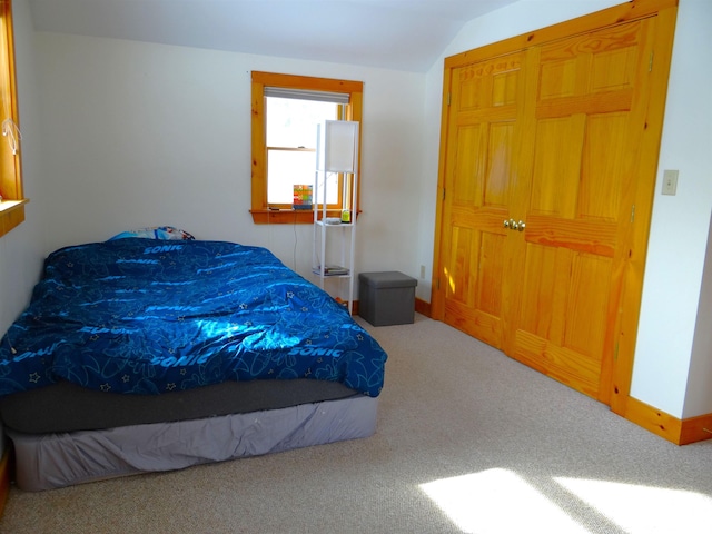 carpeted bedroom with lofted ceiling