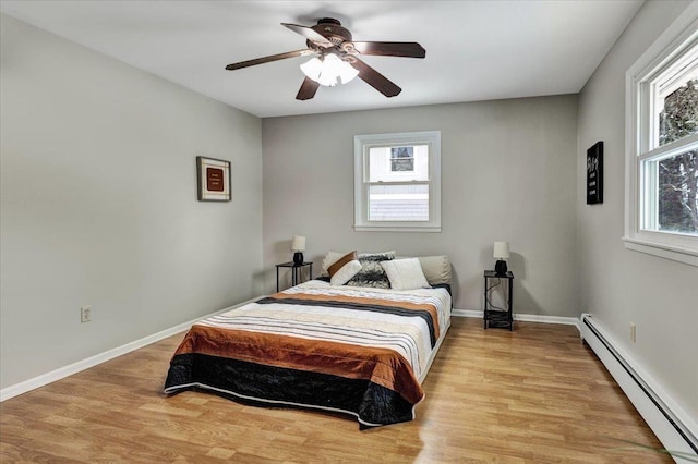 bedroom featuring a baseboard radiator, ceiling fan, and light hardwood / wood-style flooring