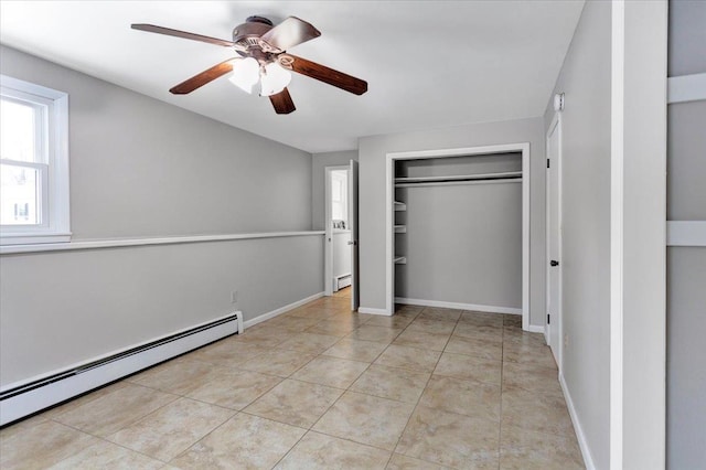 unfurnished bedroom with a baseboard heating unit, light tile patterned floors, ceiling fan, and a closet