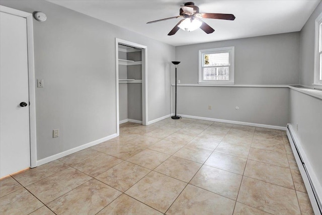 unfurnished bedroom with light tile patterned flooring, ceiling fan, baseboard heating, and a closet