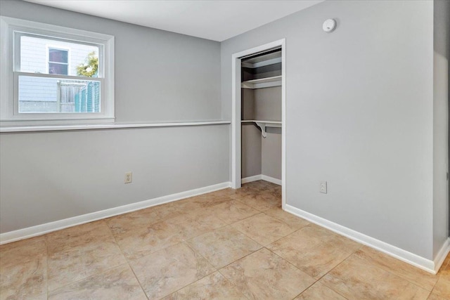 unfurnished bedroom with light tile patterned flooring and a closet