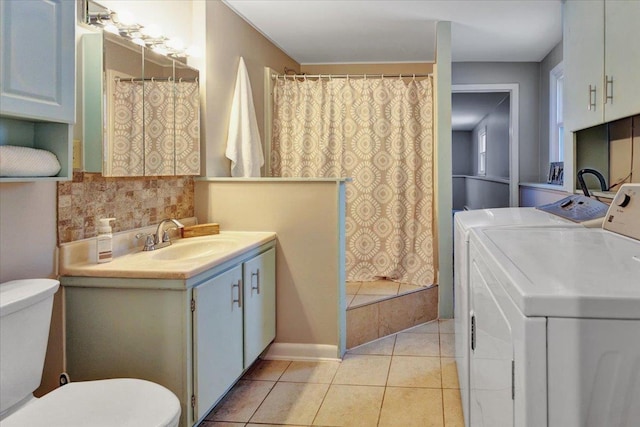 bathroom with tile patterned floors, vanity, toilet, and washing machine and dryer