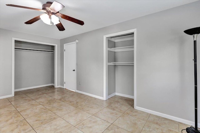 unfurnished bedroom with multiple closets, ceiling fan, and light tile patterned floors