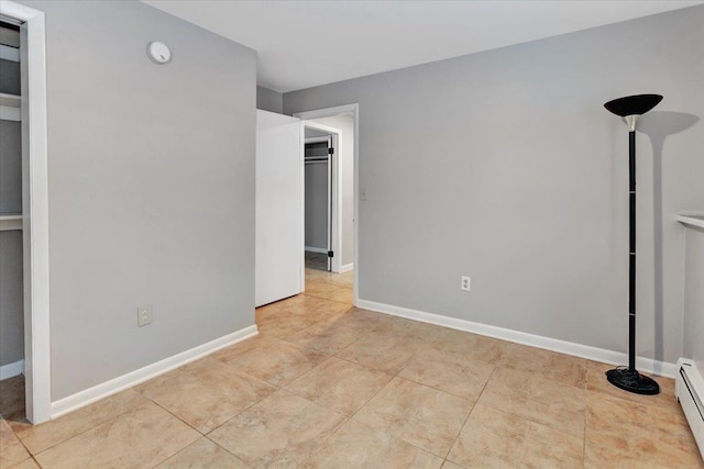 tiled empty room with a baseboard radiator