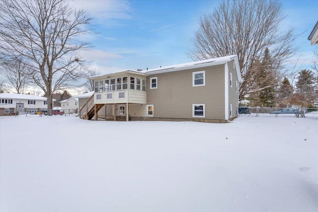 snow covered property with a sunroom