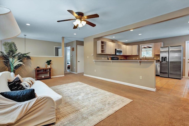 carpeted living room with ceiling fan